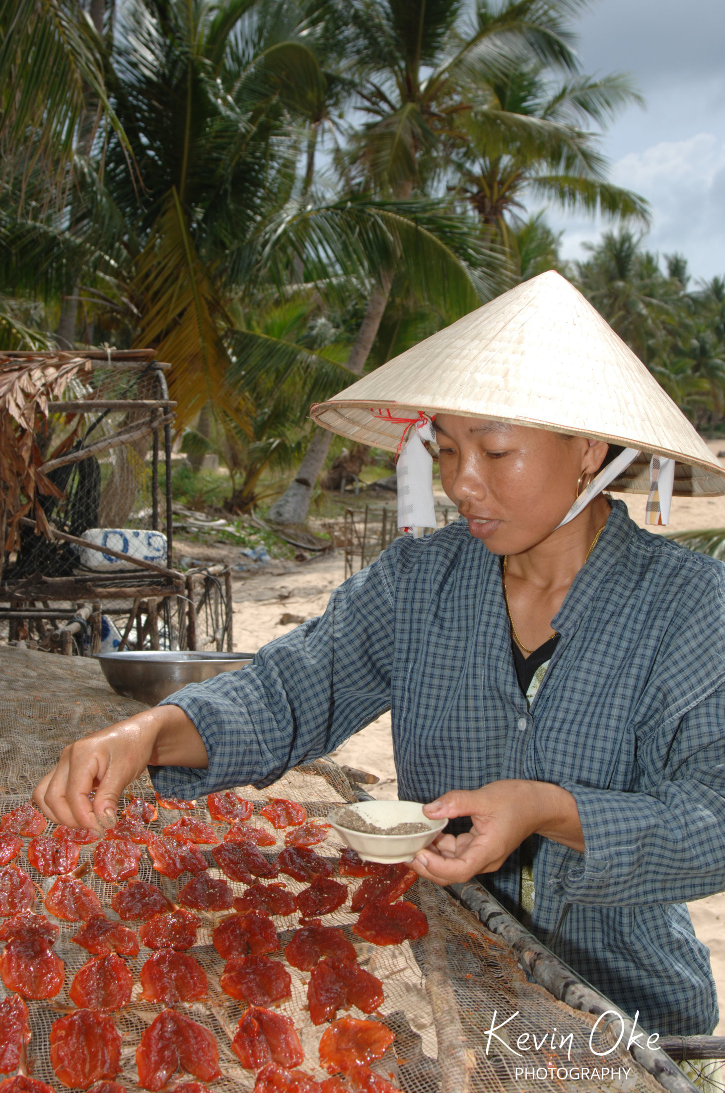 Vietnamese women spicing dried fish on Tho'm Island, An Thoi, Phu Quoc, Kien Giang Province , Vietnam